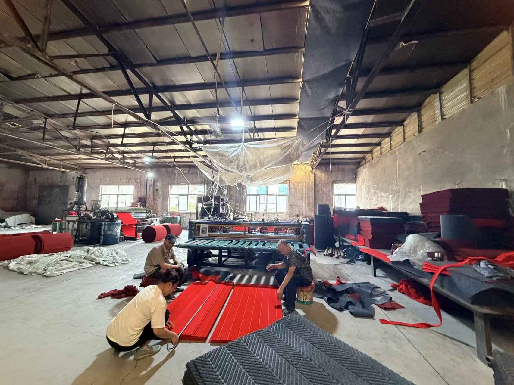 Workers finishing red floor mats